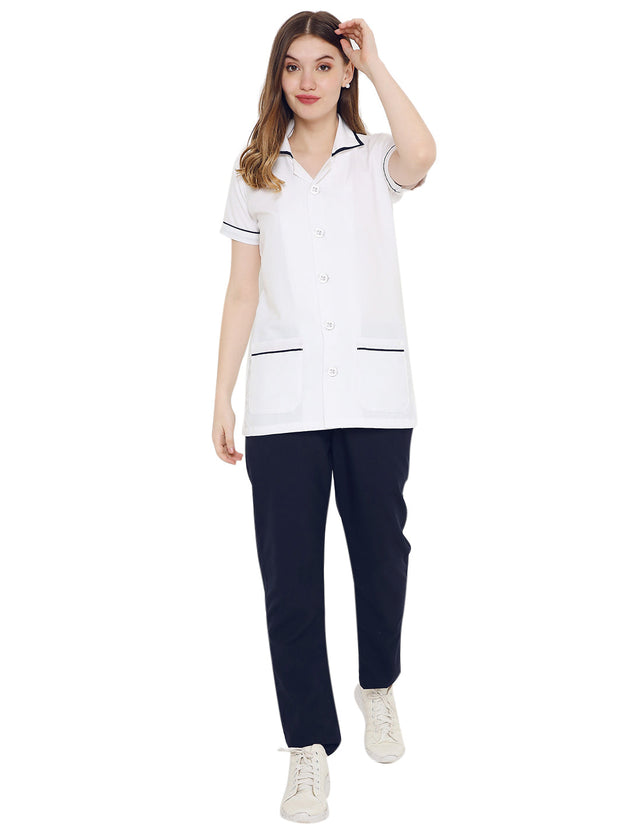Women's nurse apron and pant set in white and navy, featuring half sleeves and pockets for functionality.