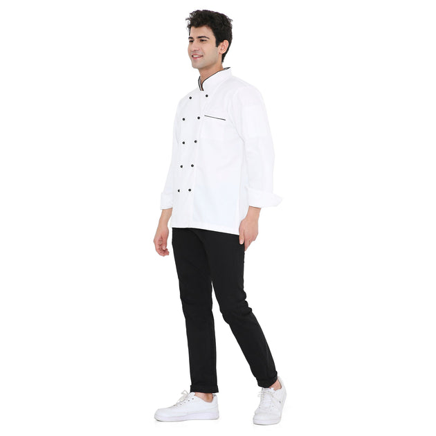 Male chef wearing a classic full sleeve white chef coat with black buttons and pants, showcasing a stylish and professional look.