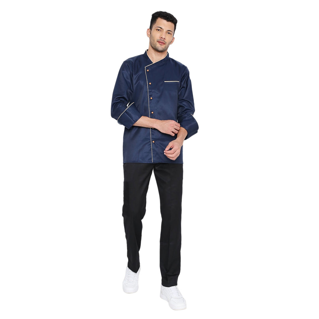 Navy blue full sleeve chef coat with cream piping, featuring french cuffs and knife pocket, worn by a chef.