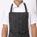 Black white broad line apron flat lay — adjustable neck strap and waist tie